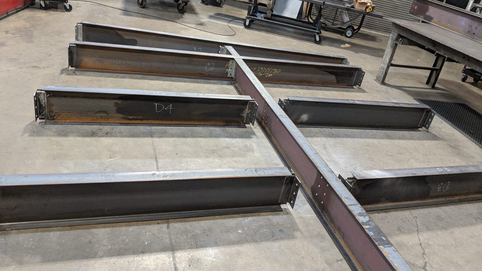 Fabricated beams with piece marks on the shop floor